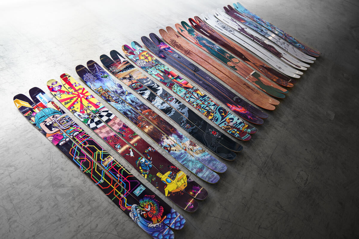 A collection of alpine skis with diverse graphics, showcasing the variety of styles and designs available for every skier.