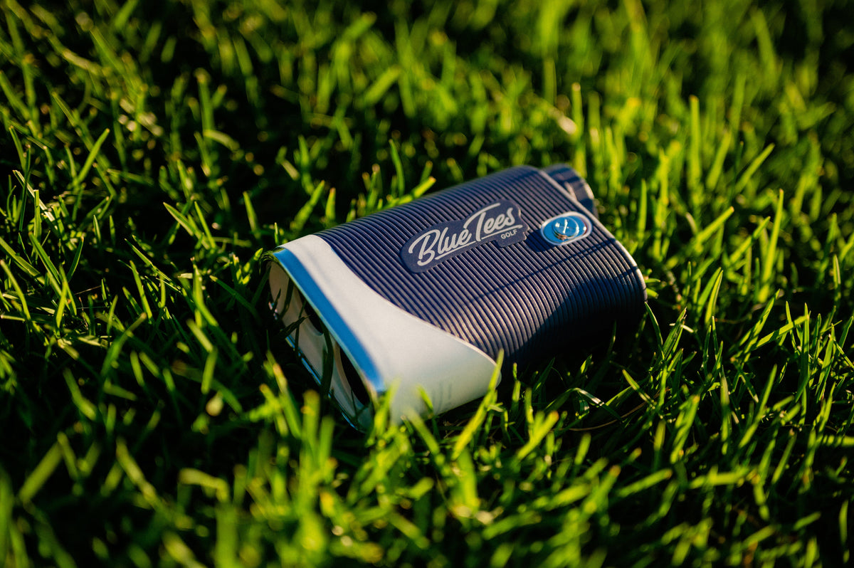 A Blue Tees Golf laser rangefinder on green grass, providing accurate distance measurements and slope technology.
