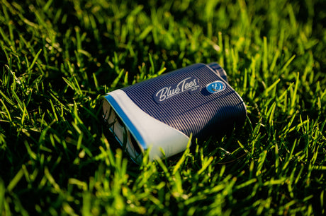 A Blue Tees Golf laser rangefinder on green grass, providing accurate distance measurements and slope technology.