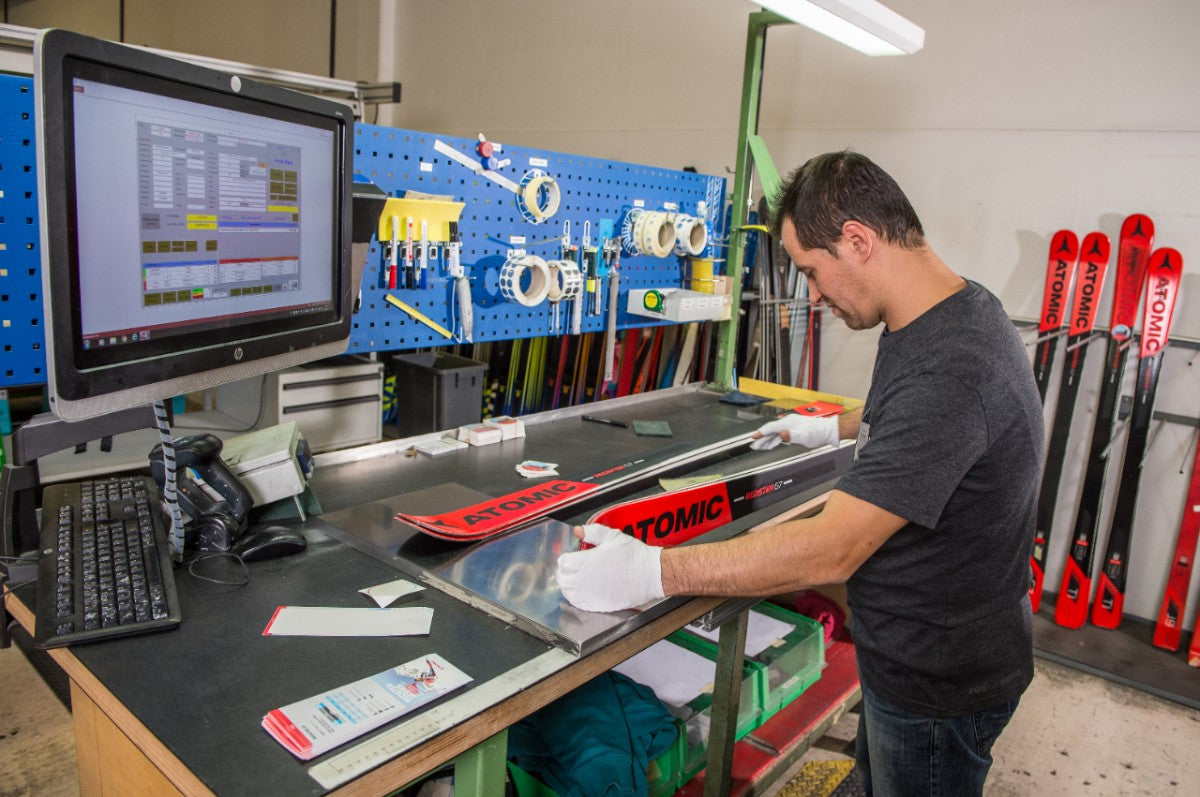 A technician assembling Atomic skis, highlighting the precision engineering and high-quality materials in ski construction.
