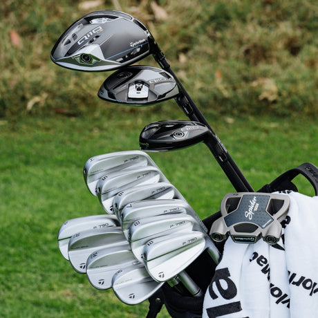 Close-up of a complete TaylorMade club set including high-performance irons, woods, and a mallet putter for golfers.