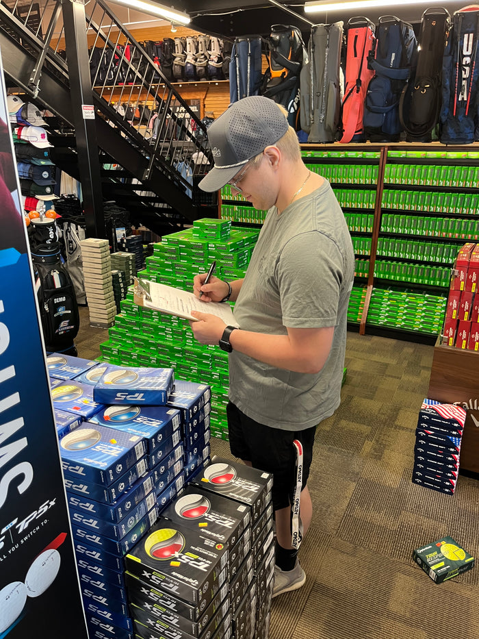 An Inventory Manager at Golfer's & Skier's Outlet performing stock counts on golf balls in Oshkosh, Wisconsin.