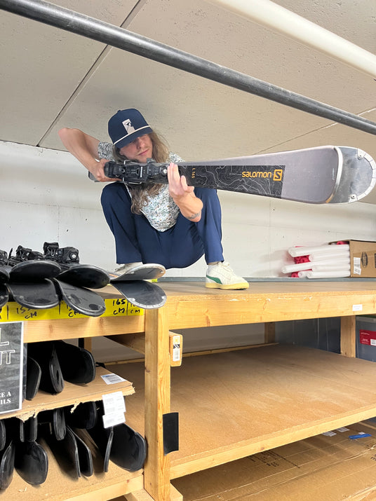 A Ski and Snowboard Service Manager inspecting Salomon skis at Golfer's & Skier's Outlet in Oshkosh, Wisconsin.