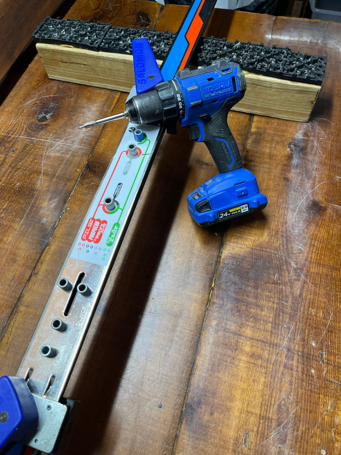 Professional cross country ski binding installation using precision mounting jigs in Oshkosh, Wisconsin.